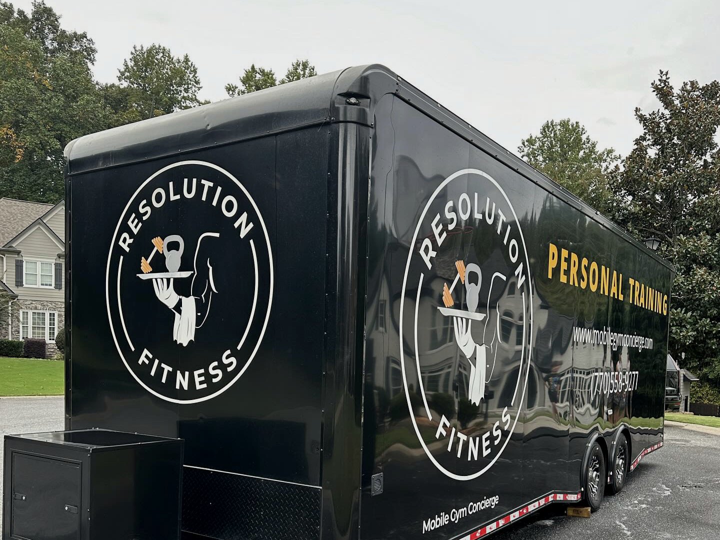 The Resolution Fitness mobile gym trailer parked on a residential street