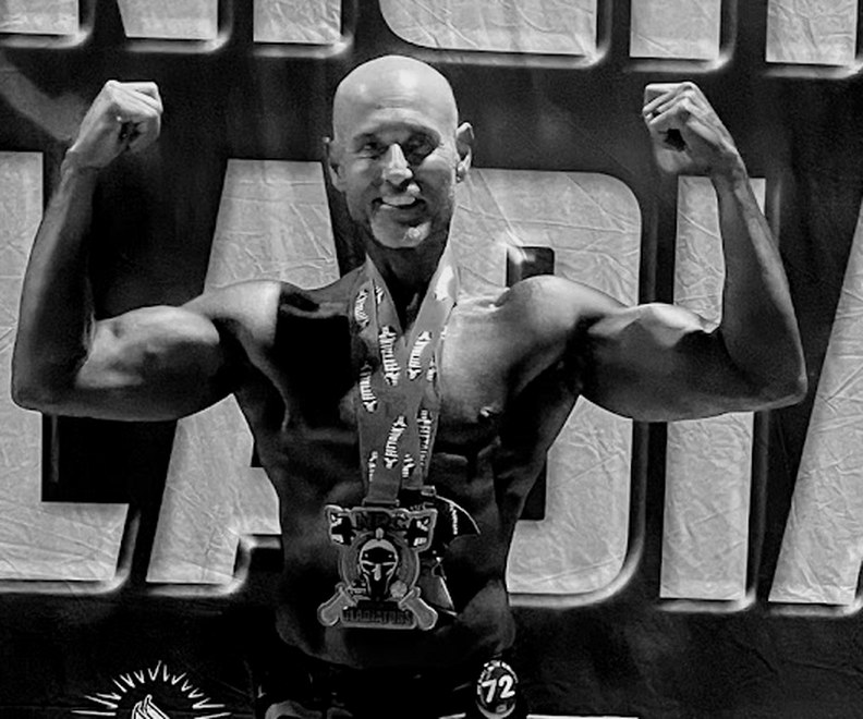 Jose Alea wearing a medal at an NPC Georgia bodybuilding competition